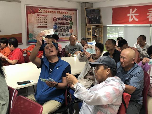 调整大小 残疾人朋友仔细观察新版人民币.jpg